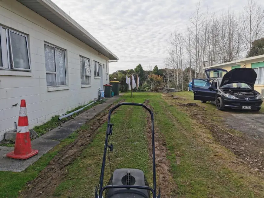 Overgrown lawn beside a house before a tidy-up in Palmerston North